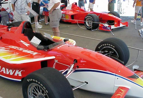 IRL car beside a F1 Ferrari.